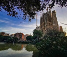 Strona główna Capture of the iconic Sagrada Familia in Barcelona at sunset with reflections on a nearby pond.